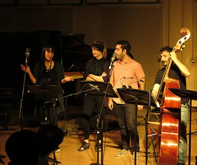 Ferhat Öz singing with a vocal ensemble and upright bass